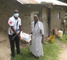 Nyadoi, an 86-year-old woman from Papoli, Uganda receives food aid.